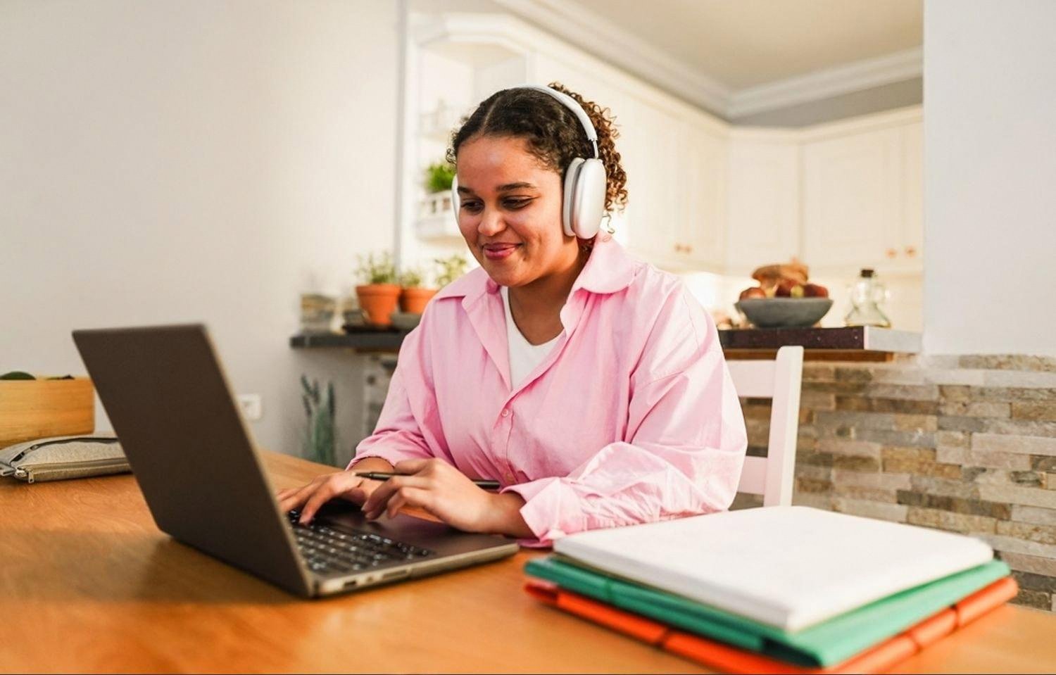 Young student wearing headphones and using a laptop for an online lesson at home